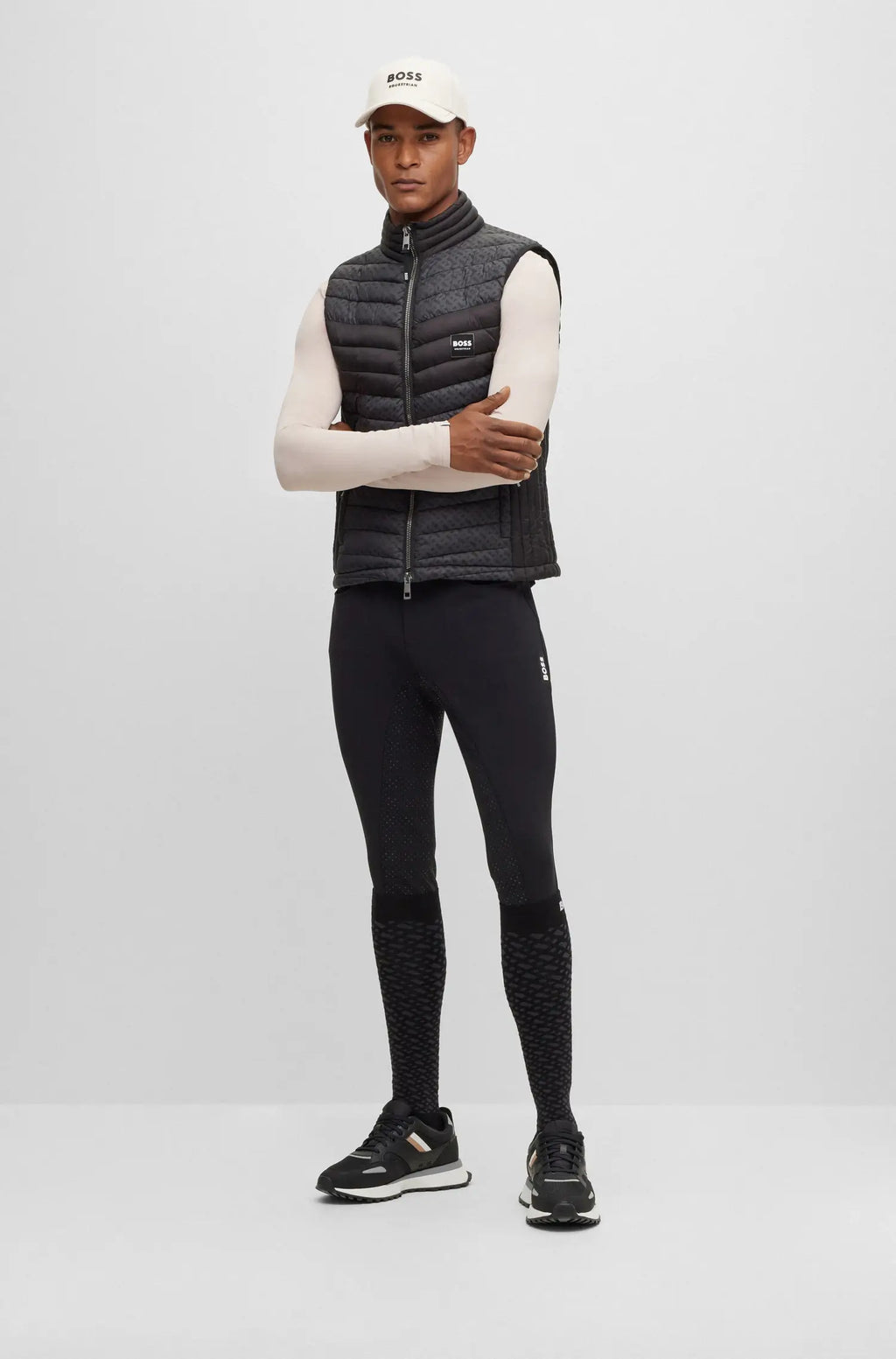 Black | Person wearing a black puffer vest, black leggings, and white long-sleeve shirt on a white background