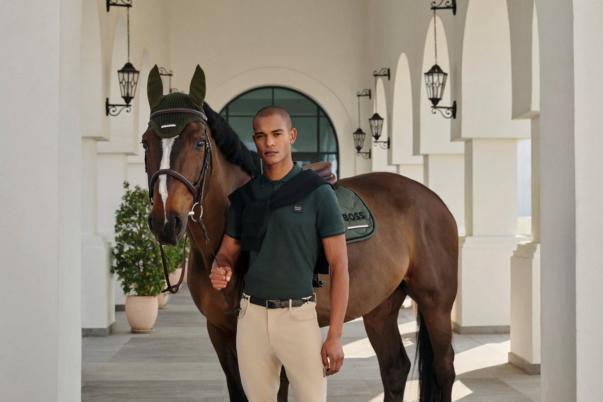 Man standing next to a horse in an elegant outdoor setting