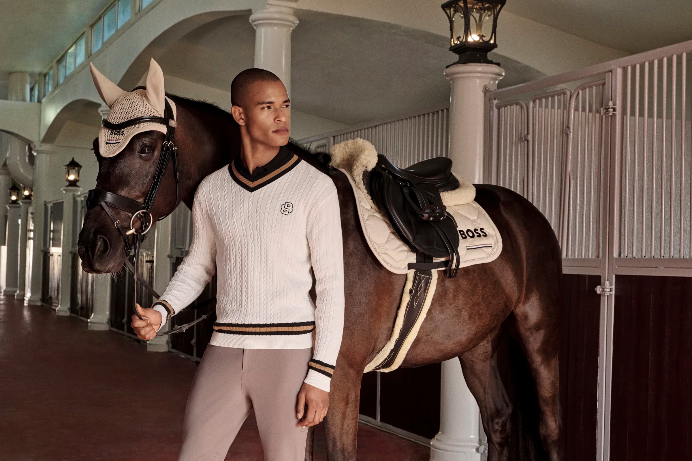 Man standing next to a horse in a stable